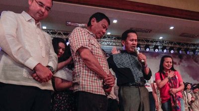 Le pasteur Apollo Quiboloy (deuxième à partir de la droite) prie avec Rodrigo Duterte, alors candidat à la présidence, lors d'une célébration d'anniversaire pendant un service de culte de remerciement à Lingayen, une ville de la province de Pangasinan, dans le nord des Philippines, le 27 mars 2016. Crédit photo : Jojo Riñoza/BenarNews.